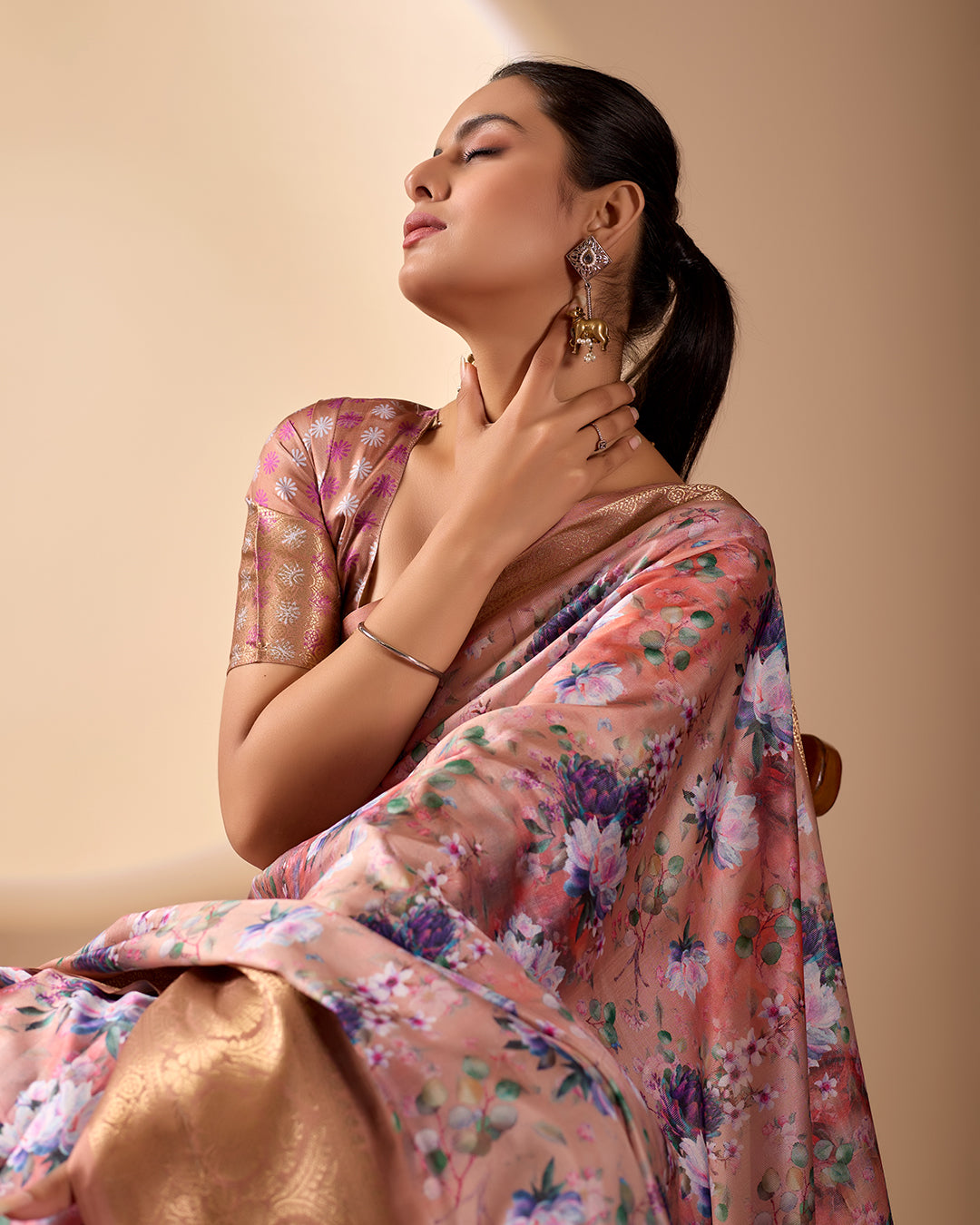 Soft Lichi Silk Saree in Rose Gold Shade enriched with elegant all-over floral digital prints and complemented by a luxurious woven zari border