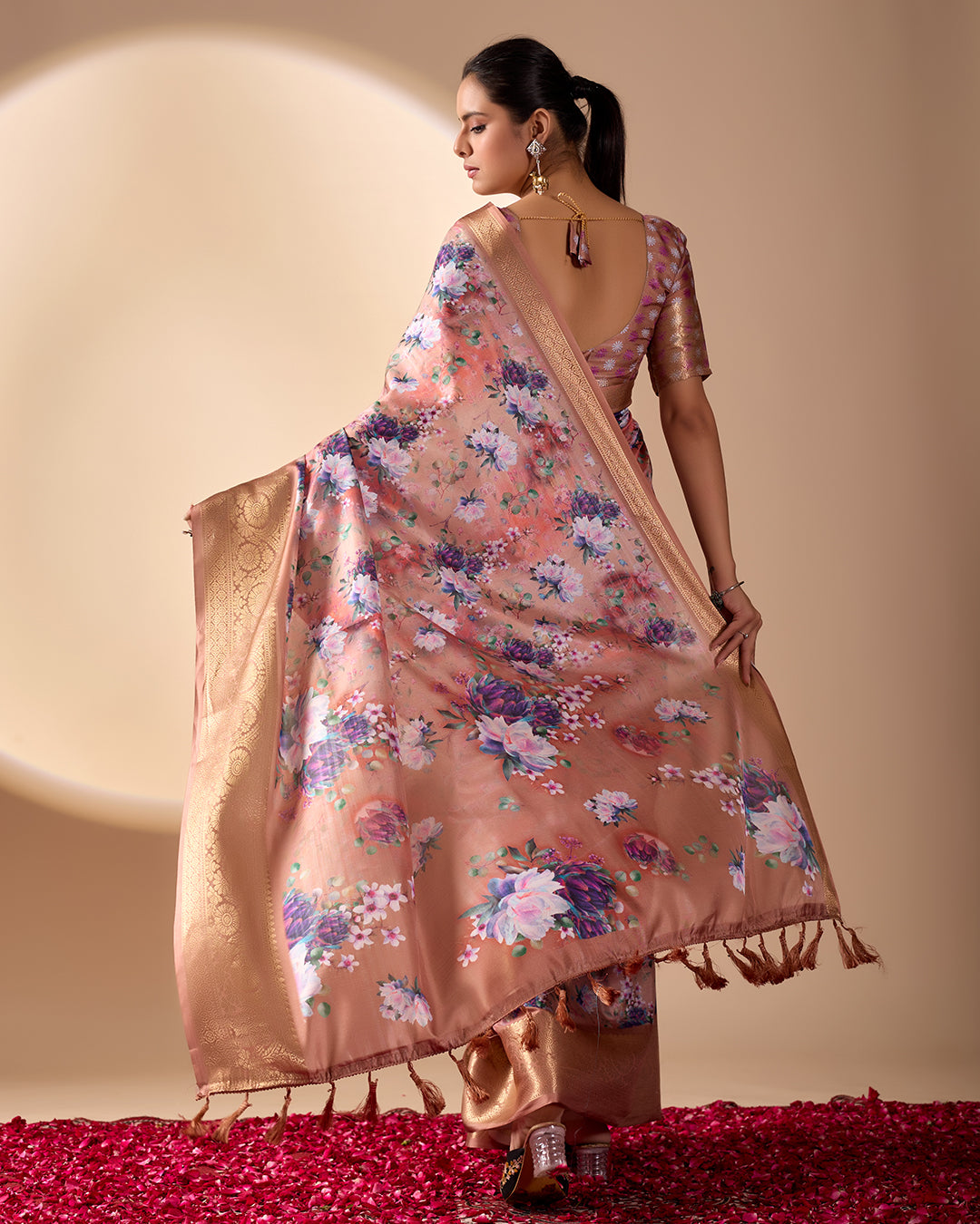 Soft Lichi Silk Saree in Rose Gold Shade enriched with elegant all-over floral digital prints and complemented by a luxurious woven zari border
